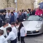 L'Arcivescovo festeggia la nuova nomina su una Porche trainata da 50 bambini (VIDEO)