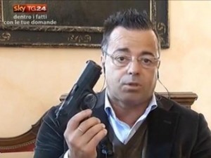 Buonanno con Pistola in Mano durante Intervista
