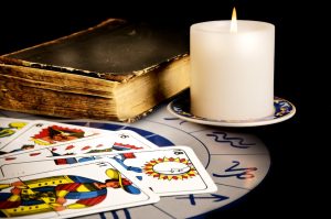 tarot cards with old book and burning candle